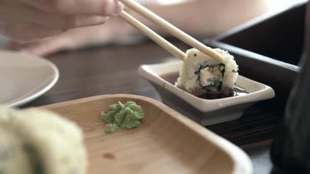 Ázsiai vendéglő látogató eszik sushi bambusz botokkal. — Stock videók