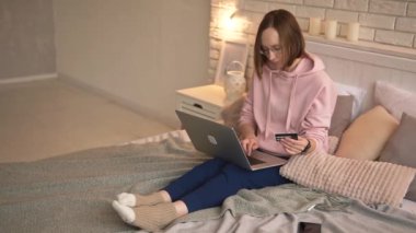 İnternetten alışveriş yapan, yemek sipariş eden, faturaları ödeyen, evinde yatağında otururken kredi kartı ve laptopla alışveriş yapan sıradan bir kız.. 