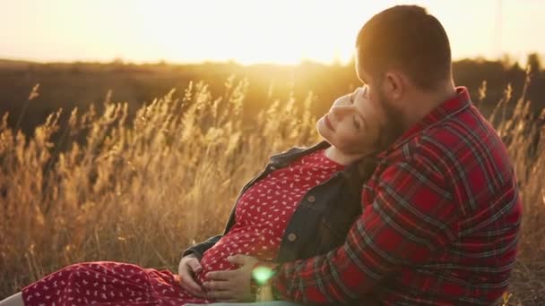 幸せな若い二人の期待の両親愛の抱きしめ場で日没時. — ストック動画