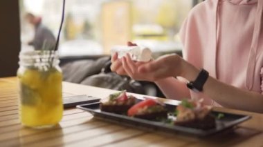 Kadın, restoranda yemek yemeden önce antiseptik jel kullanıyor..