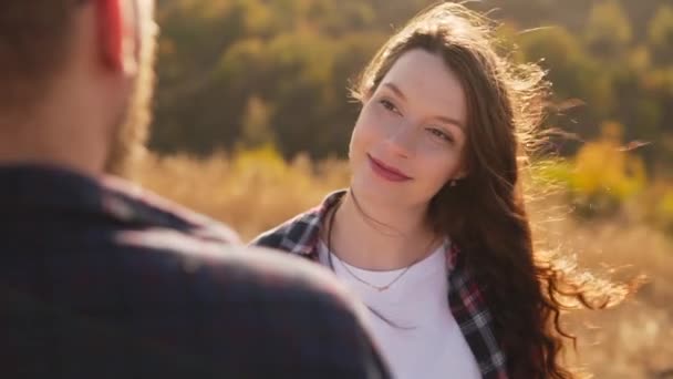 Ein junges Mädchen blickt ihrem Freund liebevoll in die Augen, der Wind streichelt ihr die Haare. — Stockvideo