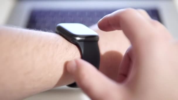 Male programmer tests app, launches script program on smartwatch with touchscreen. — Stock Video