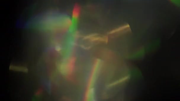 Festliche Regenbogenlinsen flackern auf. Erstaunliches Licht sickert durch. Lichter leuchten zufällig. — Stockvideo