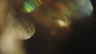 Döngüsel holografik bokeh. Moda ışık sızıntısı. Karanlık arka planda titreşen ışığın huzuru. 