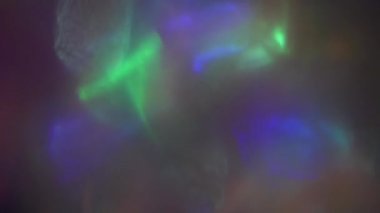 Şenlikli holografik arka plan. Moda ışık geçişleri. Işık demetleri karanlık uzayda parlar.