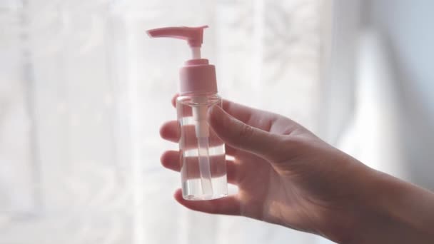 Tangan perempuan memegang dispenser dengan pembersih alkohol gel. — Stok Video