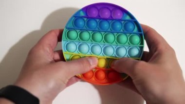 Bir adam stresi gidermek için silikon bir çocuğun üzerine baloncuk patlatır..