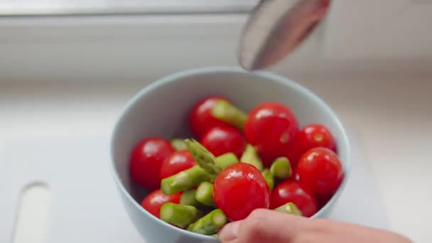 Chefs mão mistura tomates cereja e espargos no peitoril da janela. — Vídeo de Stock