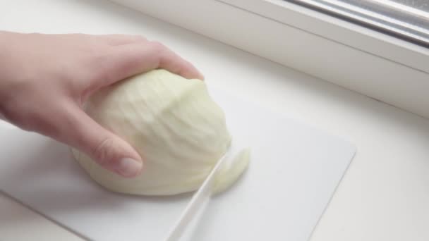 Mains masculines côtelettes chou blanc avec un couteau sur une plaque de cuisson dans la cuisine. — Video