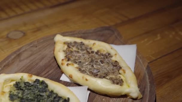 Khachapuri com espinafre e cogumelos em uma prancha de madeira. — Vídeo de Stock