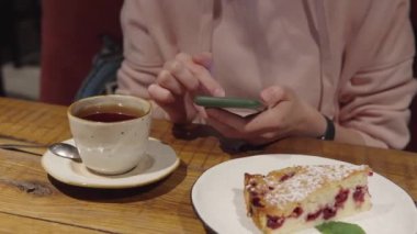 Pembe kapüşonlu genç bir kız bir sohbete, haberlere, akıllı telefondan internet sitesine giriyor..