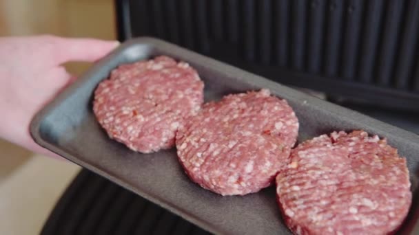 Trzy surowe kotlety mięsne hamburgery z domowym grillem elektrycznym są gotowe do grillowania. — Wideo stockowe