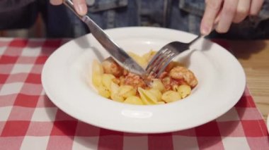 Bir kadın restoranda tavuk köftesiyle makarna yiyor..