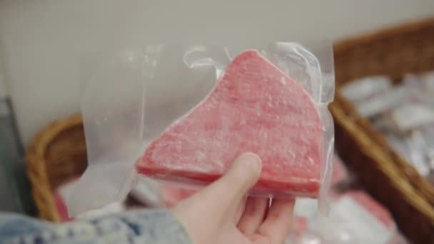 Eine Frau wählt ein tiefgefrorenes Thunfischsteak in der Supermarkt-Tiefkühltruhe. — Stockvideo