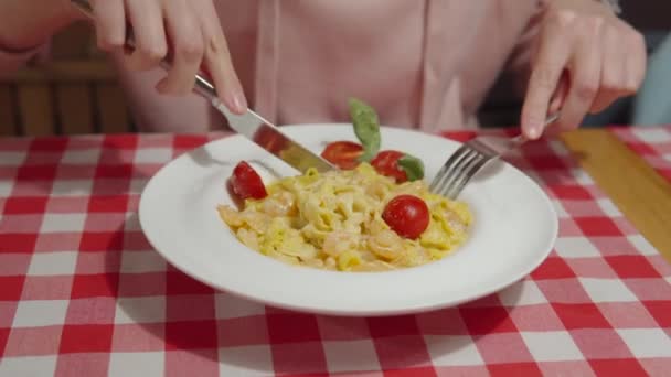 Mujer comiendo pasta de calabaza italiana con camarones, salsa, tomates y albahaca en un restaurante italiano. — Vídeos de Stock