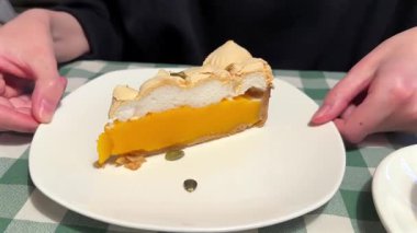 Beyaz tabakta kremalı bir dilim kabak turtası.