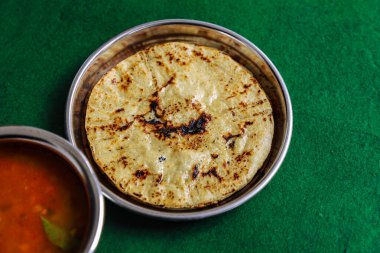 Baharatlı, siyah gram nabız tarifli ev yapımı Hint mısır ekmeği. Makki ki Roti ve Urad Dahl.