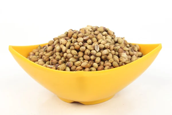 Coriander seeds in a yellow melamine bowl isolated on white background — Stock Photo, Image