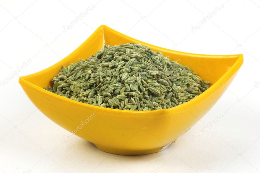 Fennel seeds in a yellow bowl isolated on white background