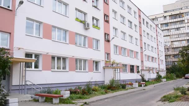 Lakóépület Szovjetunió szigetelt vakolt ház színes gesztenyebarna csíkok és virágcserepek az ablakok és erkélyek. tégla homlokzat. Az épület külső zöld fallal rendelkezik — Stock videók