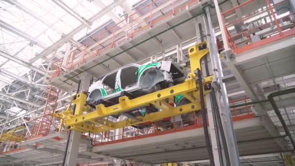 コンベア上の車のボディ。工場で近代的な車のアセンブリ。自動化されたビルドプロセス。ロボットのグループは、現代車4kのボディの組み立てと溶接に関する共同作業を実行します — ストック動画