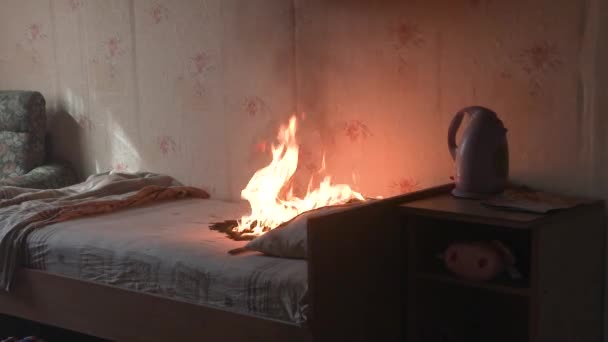 The bedroom is on fire with a lot of smoke. The bed, bedside table, plastic teapot, wallpaper and bookshelves are in flames in a residential home. Cinematic shot of aftermath of a two alarm fire 4k — Stock Video