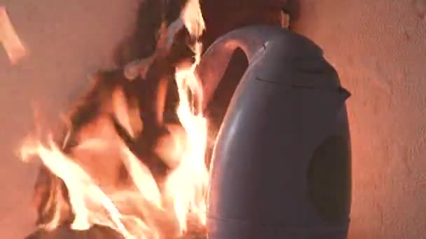 Primer plano El hervidor de agua en la habitación de la cocina está ardiendo con una llama roja. El plástico se funde. Alta temperatura. Casa destruida por el fuego. Incendio en una zona residencial en un apartamento con una habitación ahumada 4k — Vídeo de stock