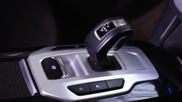 Close-up van de automatische moderne schakelknop. De zilverkleurige zwarte versnellingspook van een luxe auto. Versnellingsbak shift knop in sport auto interieur rail. Onderdelen van het interieur. Autorijden concept 4k — Stockvideo