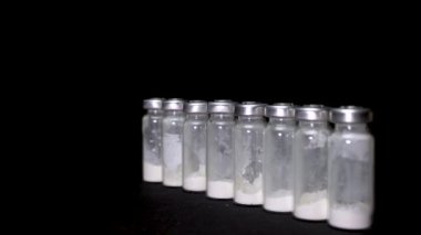 Salgın konseptinin sonu. Aşı şişeleri ve ampullerle Coronavirus bağışıklık tedavisi. Doktorun eli, koronavirüs aşısı için aşı şişesi alır. Covid-19 aşı tedavisi 4k