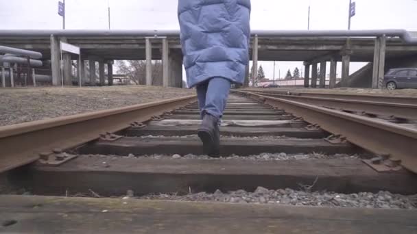 Touristenbeine laufen auf der Eisenbahn Mitte der Eisenbahn.Einsame Frau Füße in Jeans zu Fuß auf der Schiene Straße, wenn Zug oder Tram abgesagt haben.Mädchen läuft zu Hause auf Bahngleisen nach gestrichener Straßenbahn Öffentlicher Verkehr — Stockvideo