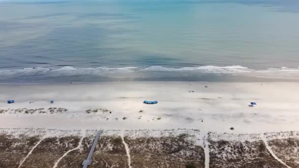 4K Aerial drone shot of Beach coastline with the blue Ocean with waves coming in and beach with nice houses on the background. Subúrbio americano. Sol brilhante ilumina a natureza tropical deslumbrante — Vídeo de Stock