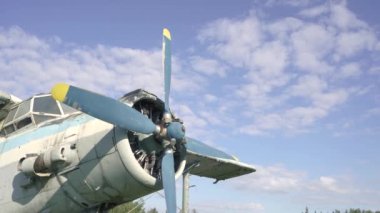 Eski SSCB uçağının kokpit gövdesine yakın çekim. Ağır çekimde gün batımına karşı yoğun çimlerde duruyor. Hava alanında uçmak için terk edilmiş Sovyet uçakları. Terk edilmiş uçak 4k