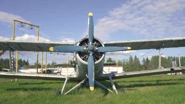 遅い動きで日没に対する過成長フィールドの厚い草の中に立っている古いソ連の飛行機のコックピット胴体のクローズアップ。ソ連は空港での飛行のために航空機を放棄した。放棄された航空機4k — ストック動画