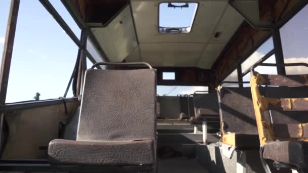 Une vieille cabine cassée rouillée d'un autobus abandonné avec des sièges en cuir endommagés. Cimetière Recyclage et utilisation des transports publics. Matières recyclables. Le concept de conservation de l'environnement 4k — Video