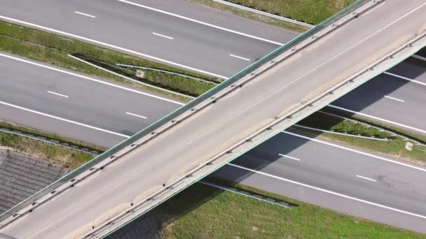 Widok drona z lotu ptaka autostrady wielopoziomowe skrzyżowanie drogi z poruszającym się czerwonym samochodem w słoneczny dzień. Pusta autostrada. Samochody poruszają się na wielopoziomowym skrzyżowaniu dróg Koncepcja miasta — Wideo stockowe