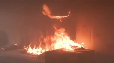 Yatak odası çok fazla dumanla yanıyor. Yatak, komodin, plastik çaydanlık, duvar kâğıdı ve kitap rafları bir konut evinde alevler içinde. 2 alarm 4K 'dan sonra çekilen sinematik çekim.