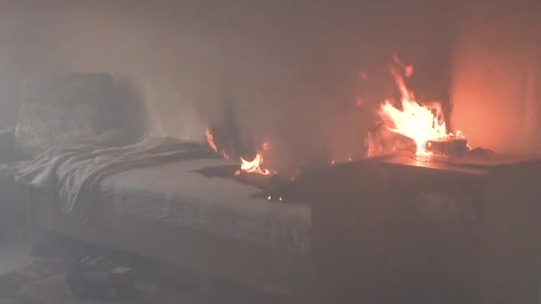 La chambre est en feu avec beaucoup de fumée. Le lit, la table de chevet, la théière en plastique, le papier peint et les étagères sont en flammes dans une maison résidentielle. Prise de vue cinématographique des suites d'un incendie de deux alarmes 4k — Video