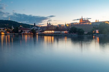 Vltava nehri ve tepe Prag 'ın eski bir kasabasında gün batımında.