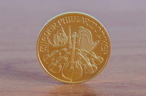 Золотая монета Венской филармонии на деревянном столе.
