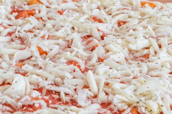 Detail of frozen margarita pizza with grated cheese on the top.