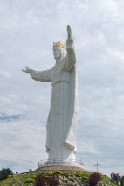 Arka planda bulutlar olan Kral İsa 'nın heykeli. Swiebodzin 'deki İsa heykelinin 33 metre yüksekliğindeki heykeli..