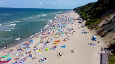 Jastrzebia Gora, Polonya - 21 Temmuz 2021: Baltık Denizi 'nde yaz mevsiminde kalabalık plajda hava manzarası. Polonya sahilinde turistler.
