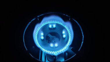 Mutfak gazının mavi alevi karanlıkta.