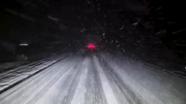 Geceleri kar yağışı sırasında araba sürmek.