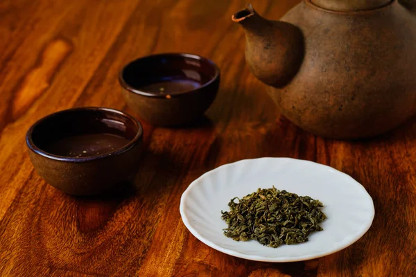 Zielona Herbata Białym Talerzu Czajniczek Miski Drewnianym Stole — Zdjęcie stockowe