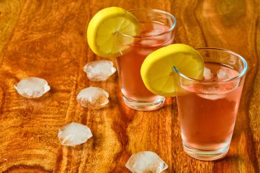 Lezzetli taze narenciye çayı ve ahşap masada limon meyvesi.