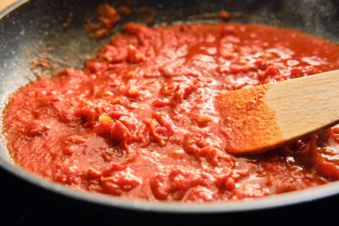 Kızartma tavasında kurutulmuş jambonlu domates sosu hazırlıyorum.