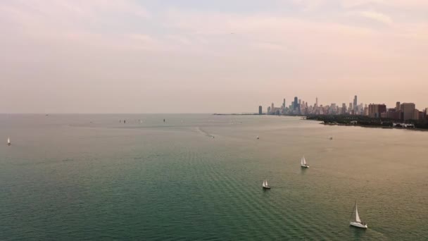 저물어 시카고의 스카이라인과 건물들이 지평선 너머로 보이기 호숫가에 범선과 하늘을 — 비디오