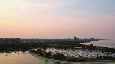 Chicago 'nun kuzeyine ve Edgewater mahallelerine bakan Montrose plajı ve limanı gün batımında teknelerle dolu olan hava uçuşu..