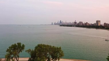 Michigan Gölü üzerinde Montrose limanı yakınlarındaki ağaçlar ve kıyı şeridi üzerinde sakin sularda yelkenli tekneleri ve ufukta ufuk çizgisi olan güzel bir hava uçuşu..